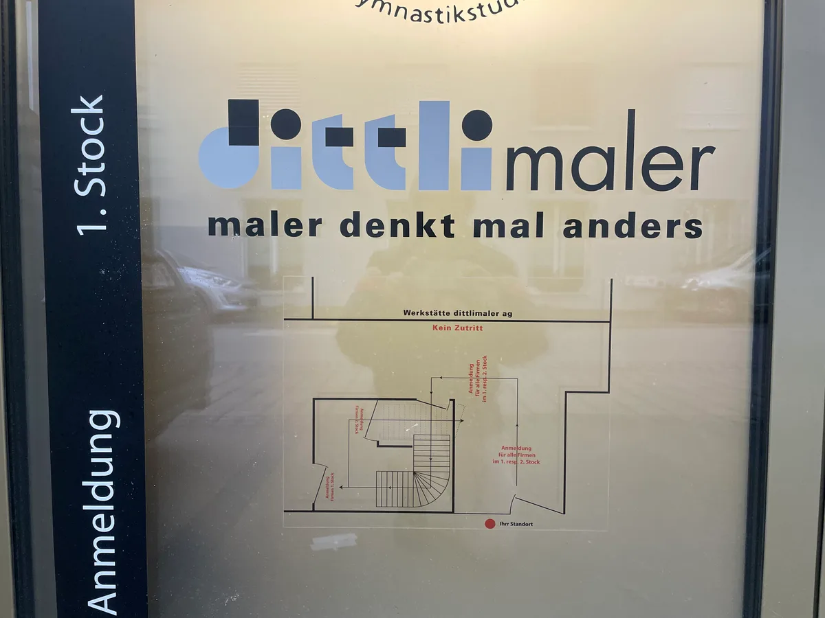 Schild vor Hauseingang mit Skizze von den Geschäftsräumen. 